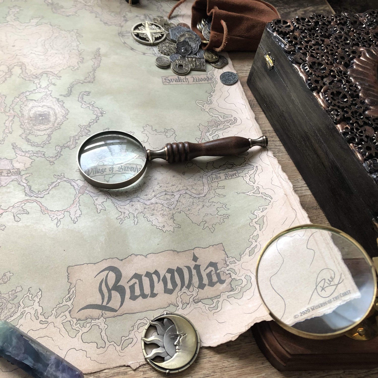 A photograph of the Icewind Dale prop map with a coin, Cartographer's supplies, and a Druid Field Journal.