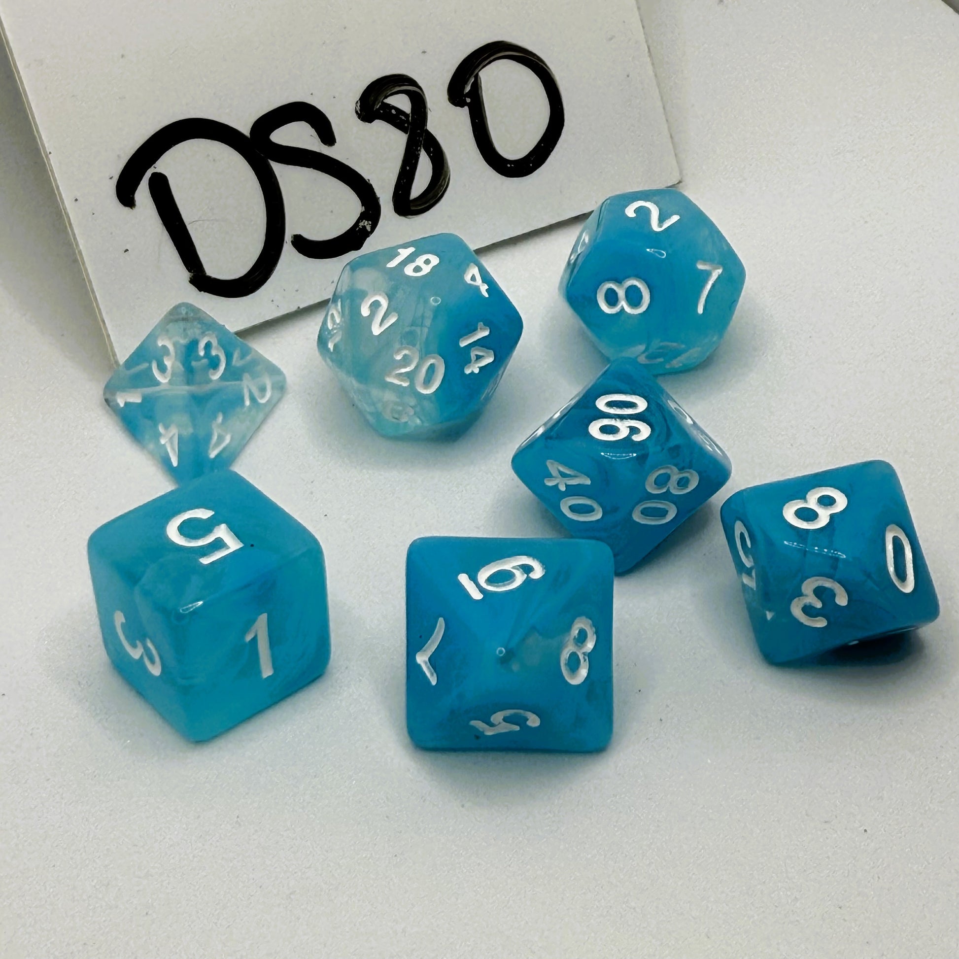 Set of sky blue dice with white numbers on a white background, labeled 'DS80' 